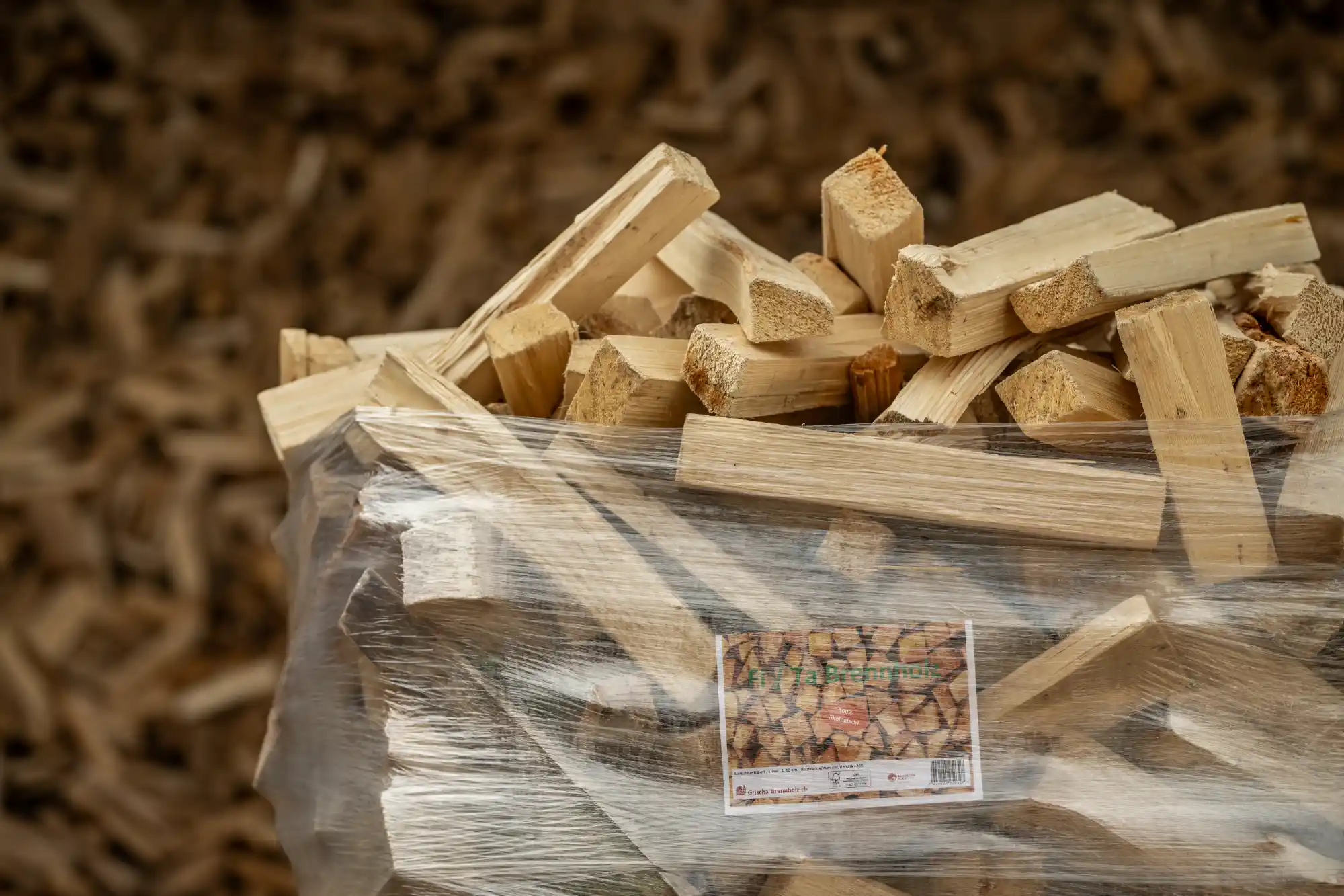 Nahaufnahme von 40 cm langen Fichten-Brennholzscheiten aus einem Ster Holzstapel mit sichtbarer Holzstruktur